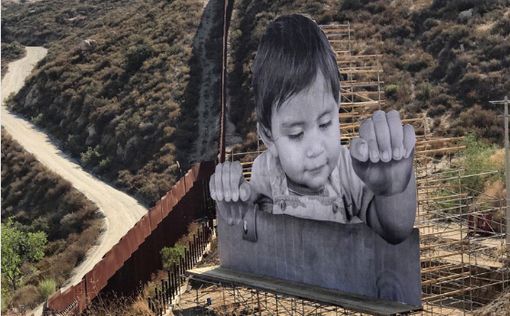 Гигантский портрет ребенка на границе США и Мексики