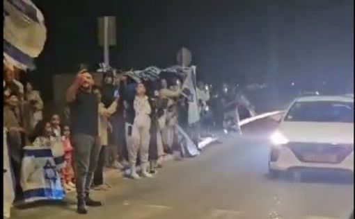 Сотни людей приветствуют машины с освобожденными израильскими заложниками