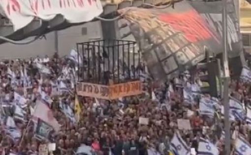 Эйнав Зангаукер в клетке над головами толпы на перекрестке Менахем Бегин: видео